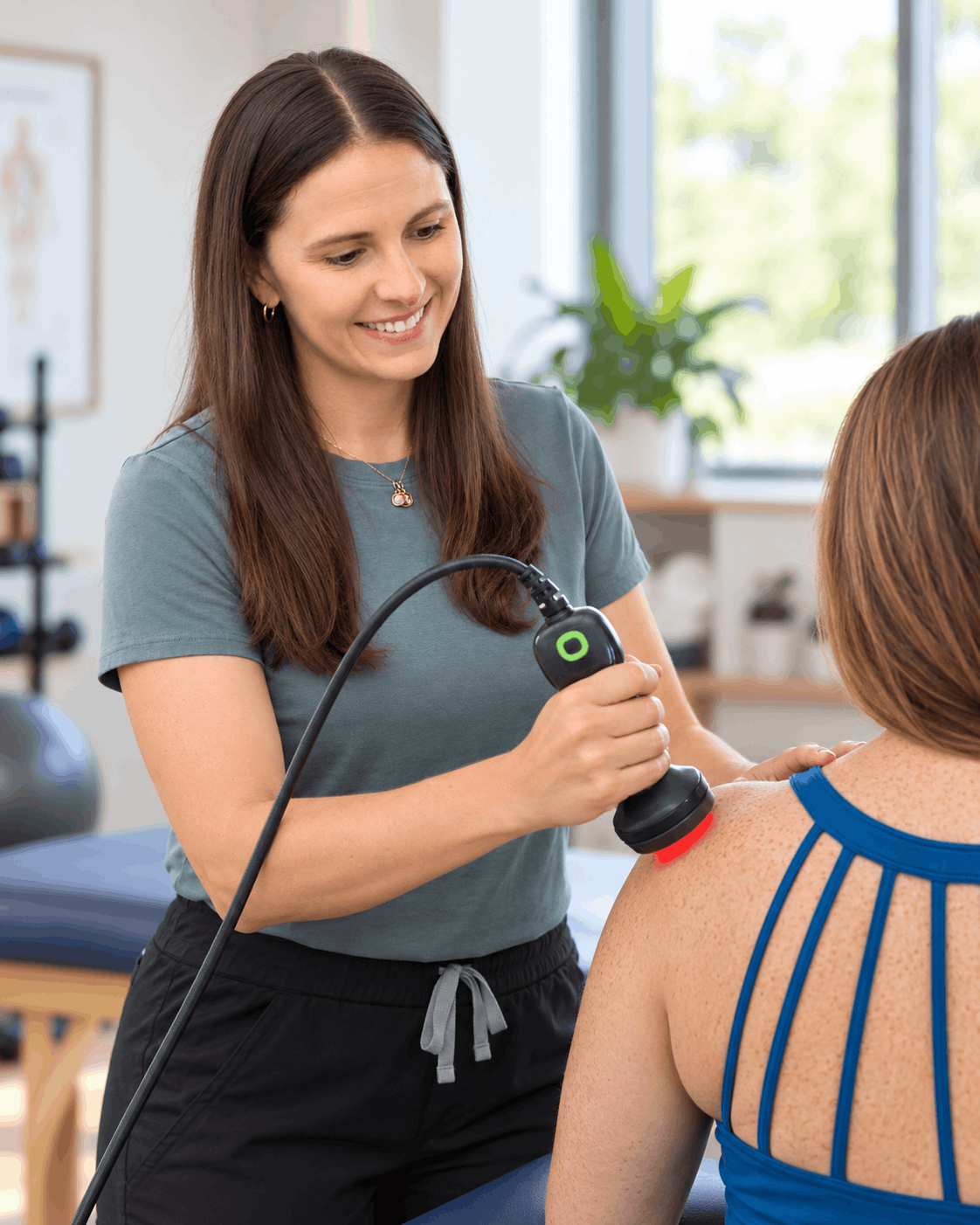 Amber performing LightForce laser therapy on a patient's shoulder